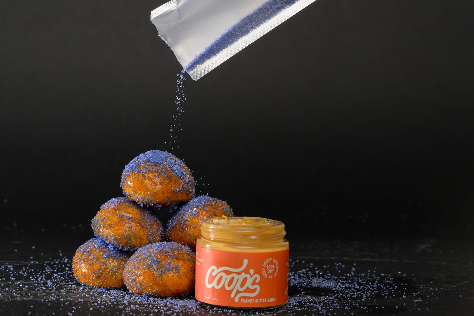 Grape jelly sugar being poured over pretzel bites
