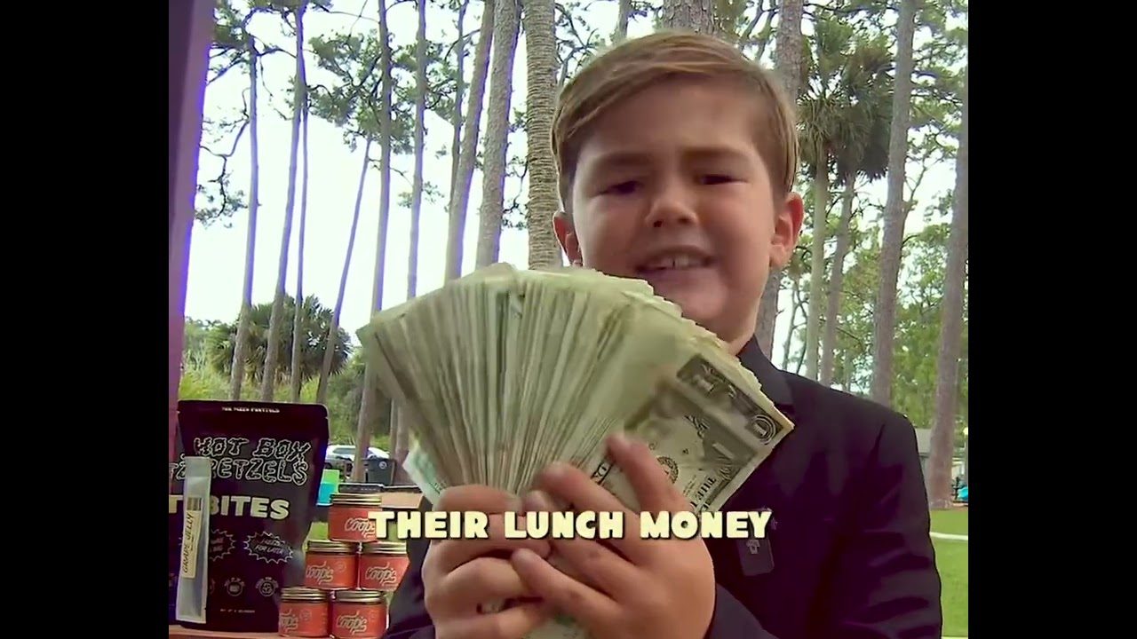 Kid in a suit at the pretzel stand holding a fan of cash